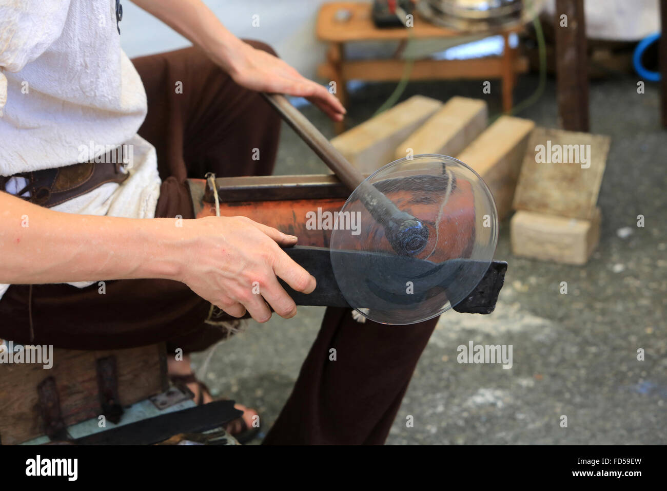 Glass Blower. Formatting glass paste. Stock Photo