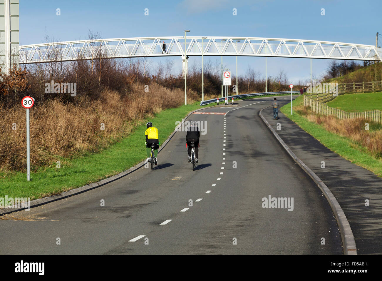 Two cyclists and a walk over bridge, Efail Isaf nr Pontypridd, Wales UK Stock Photo