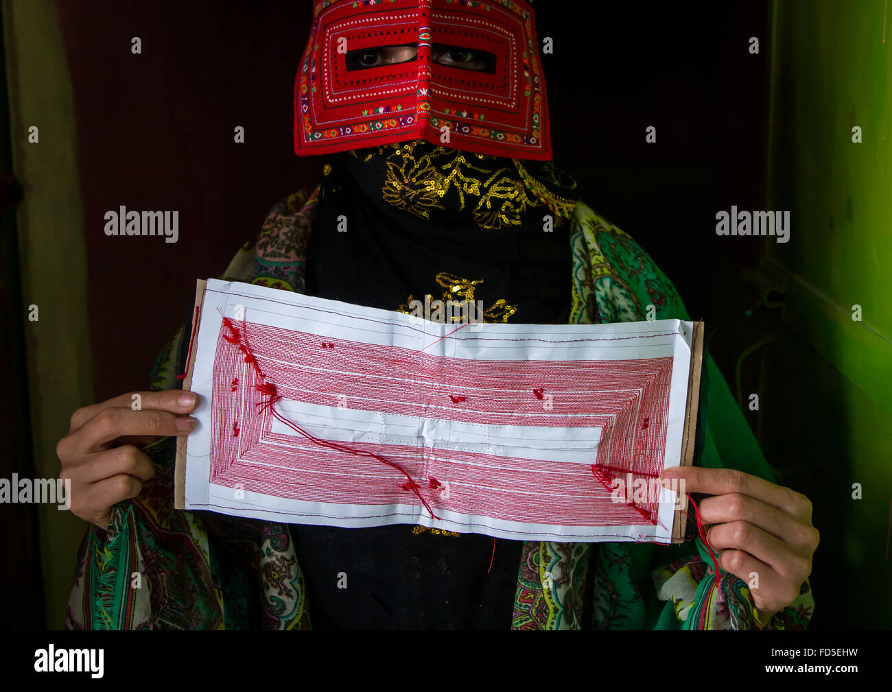 a bandari woman wearing a traditional mask called the burqa and showing ...