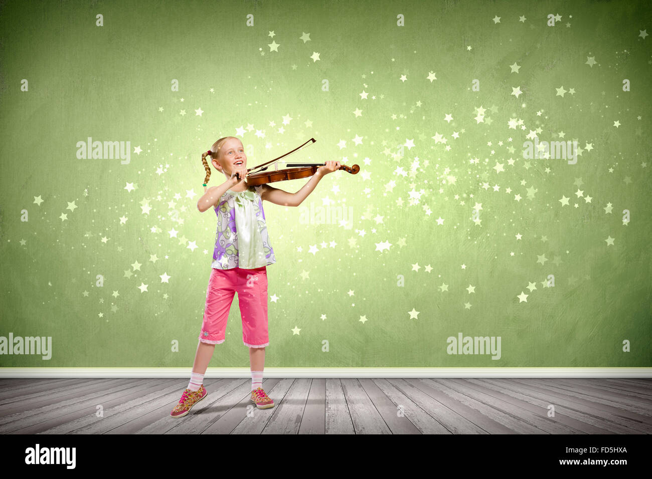 Image of cute girl playing violin against green background Stock Photo ...