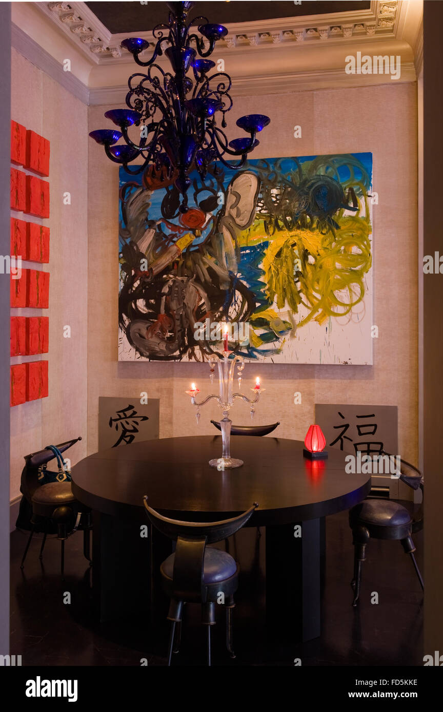 Contemporary artwork with oriental style table and chairs in collector's London apartment Stock Photo