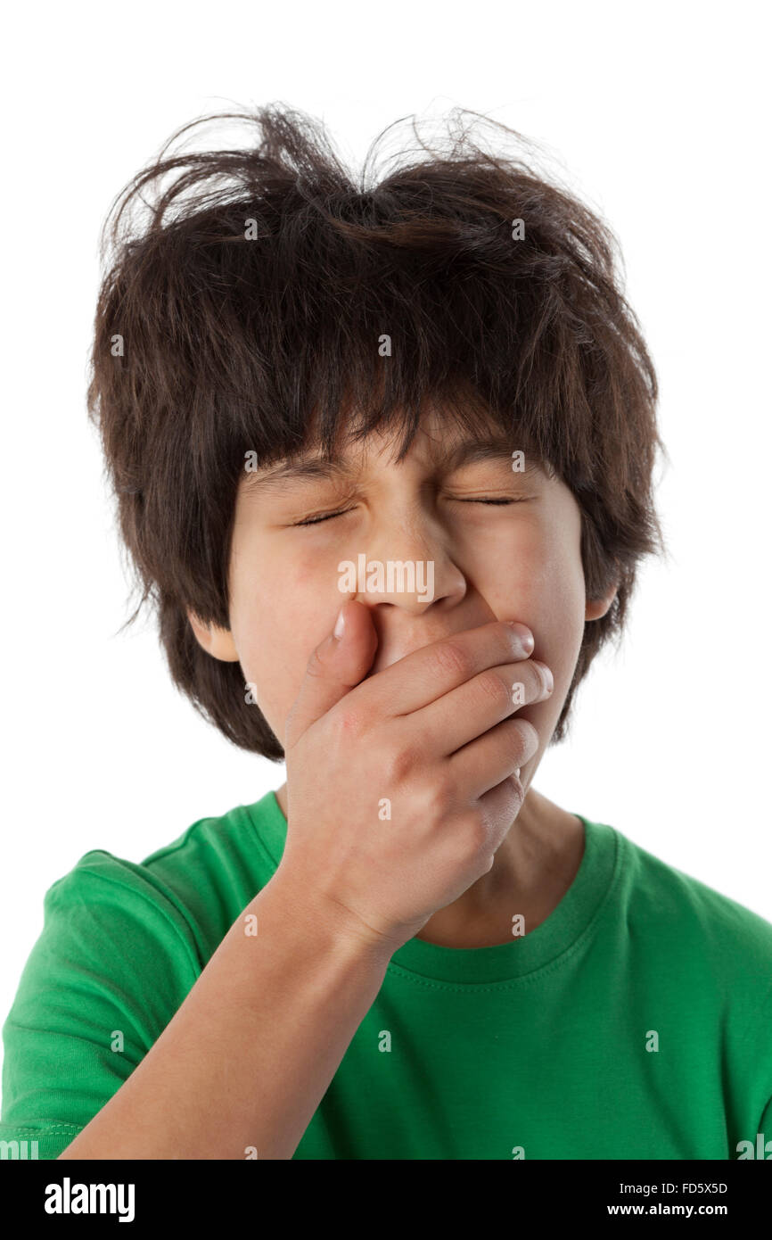 Yawning eight year old boy on white background Stock Photo