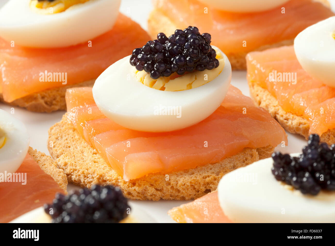 Snack with salmon,quail eggs and lumpfish roe on toast Stock Photo