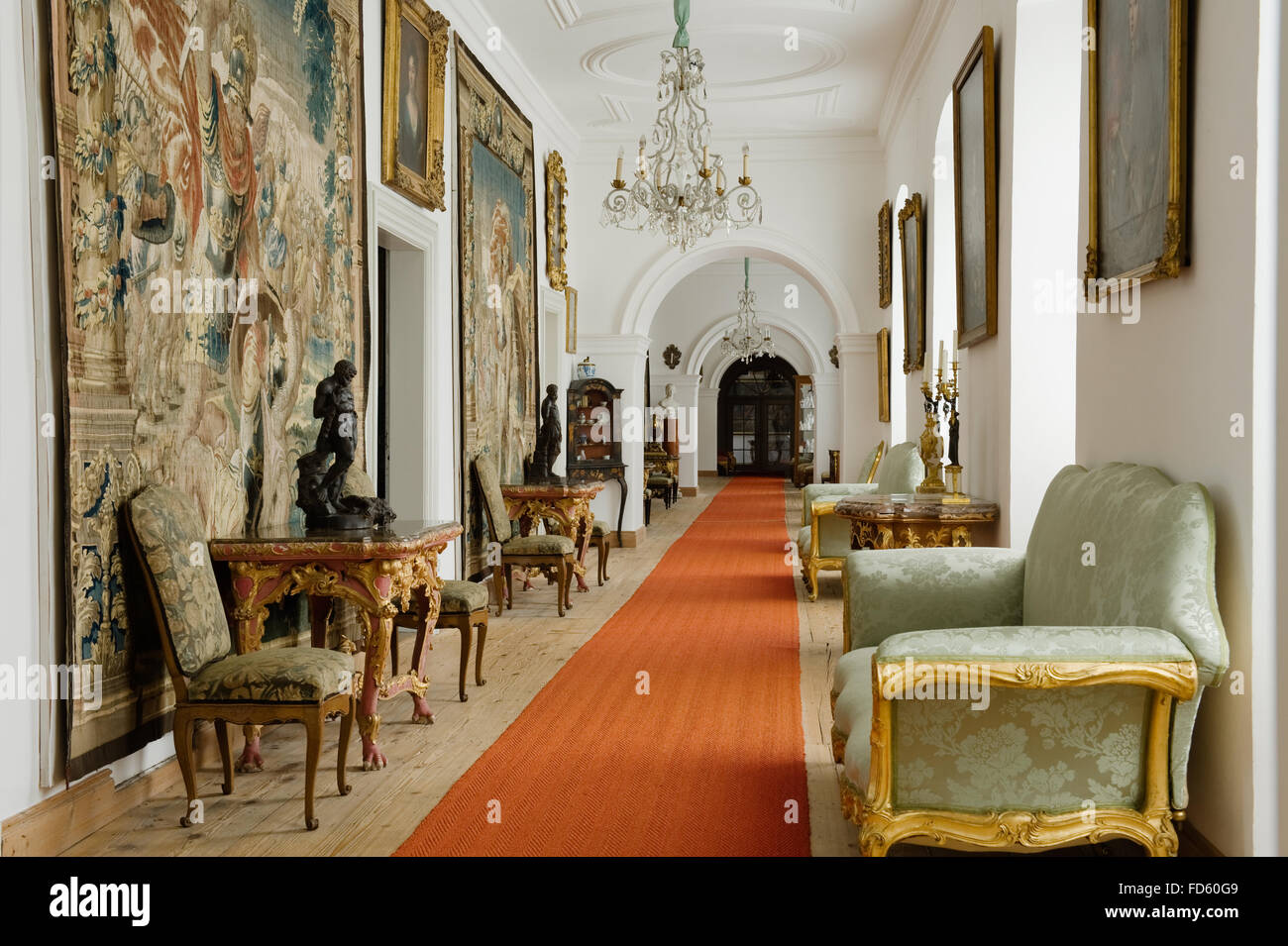 Tapestry wall hangings with antique furniture and red carpet runners in hallway of Schloss Fasanerie near Fulda in Germany Stock Photo