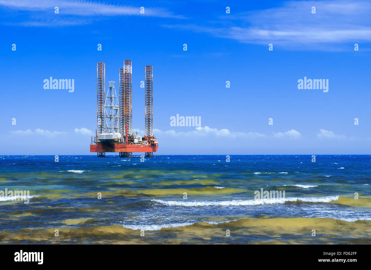 Offshore oil rig drilling platform in the sea against blue sky Stock Photo