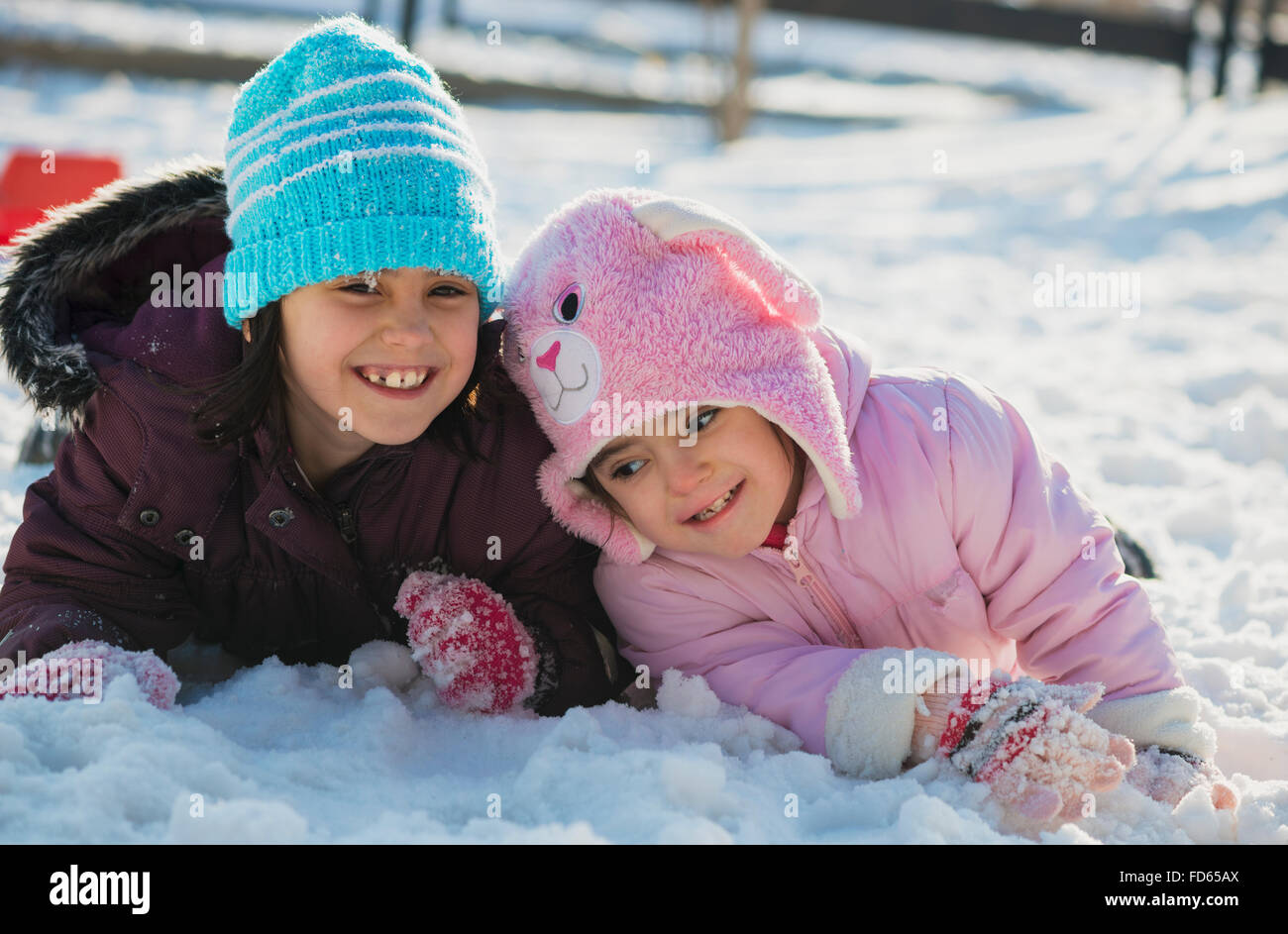 Two funny adorable little sisters playing in the snow Stock Photo