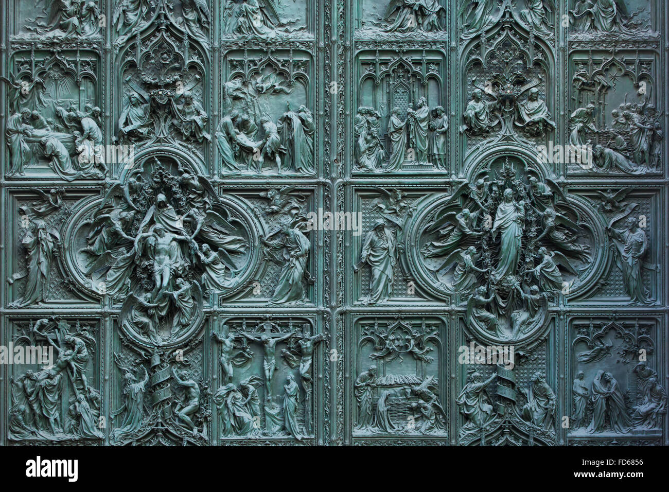 Main bronze door of the Milan Cathedral (Duomo di Milano) designed by Italian sculptor Ludovico Pogliaghi in Milan, Italy. The bronze door was designed by Italian sculptor Ludovico Pogliaghi in 1894-1908. Stock Photo