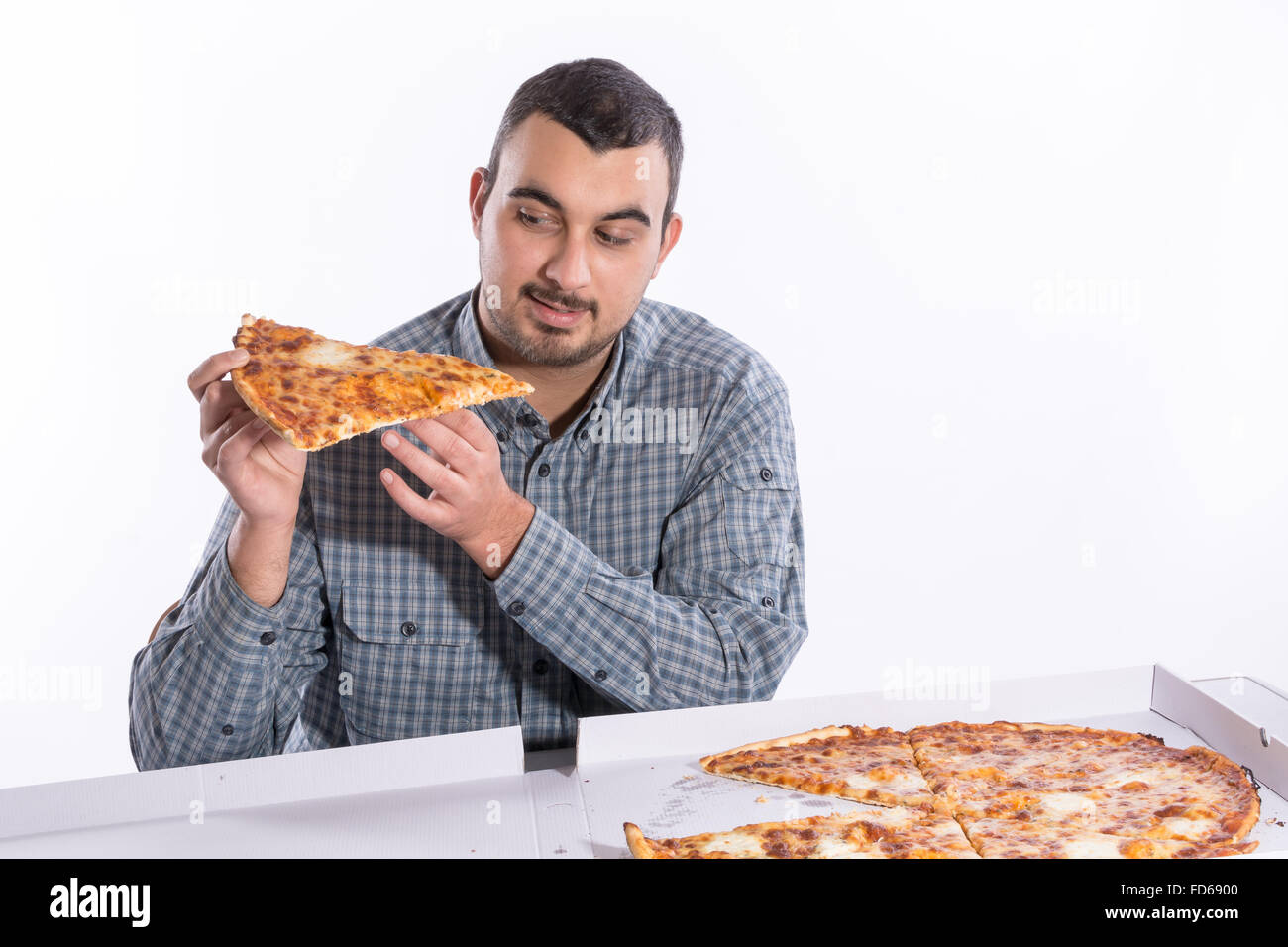 Young man eating pizza with cheese on a white background Stock Photo