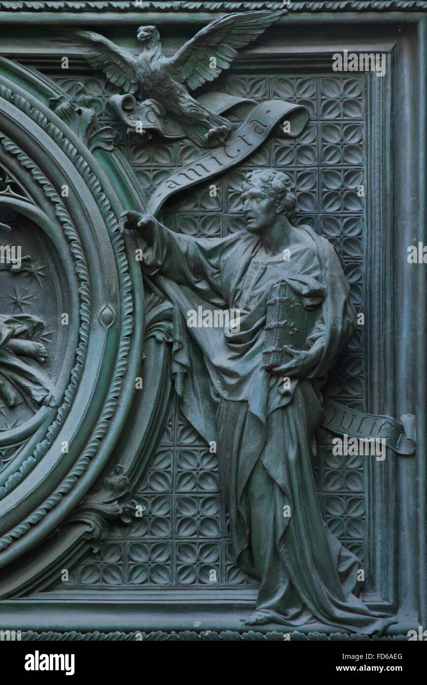 Saint John the Evangelist. Detail of the main bronze door of the Milan Cathedral (Duomo di Milano) in Milan, Italy. The bronze door was designed by Italian sculptor Ludovico Pogliaghi in 1894-1908. Stock Photo