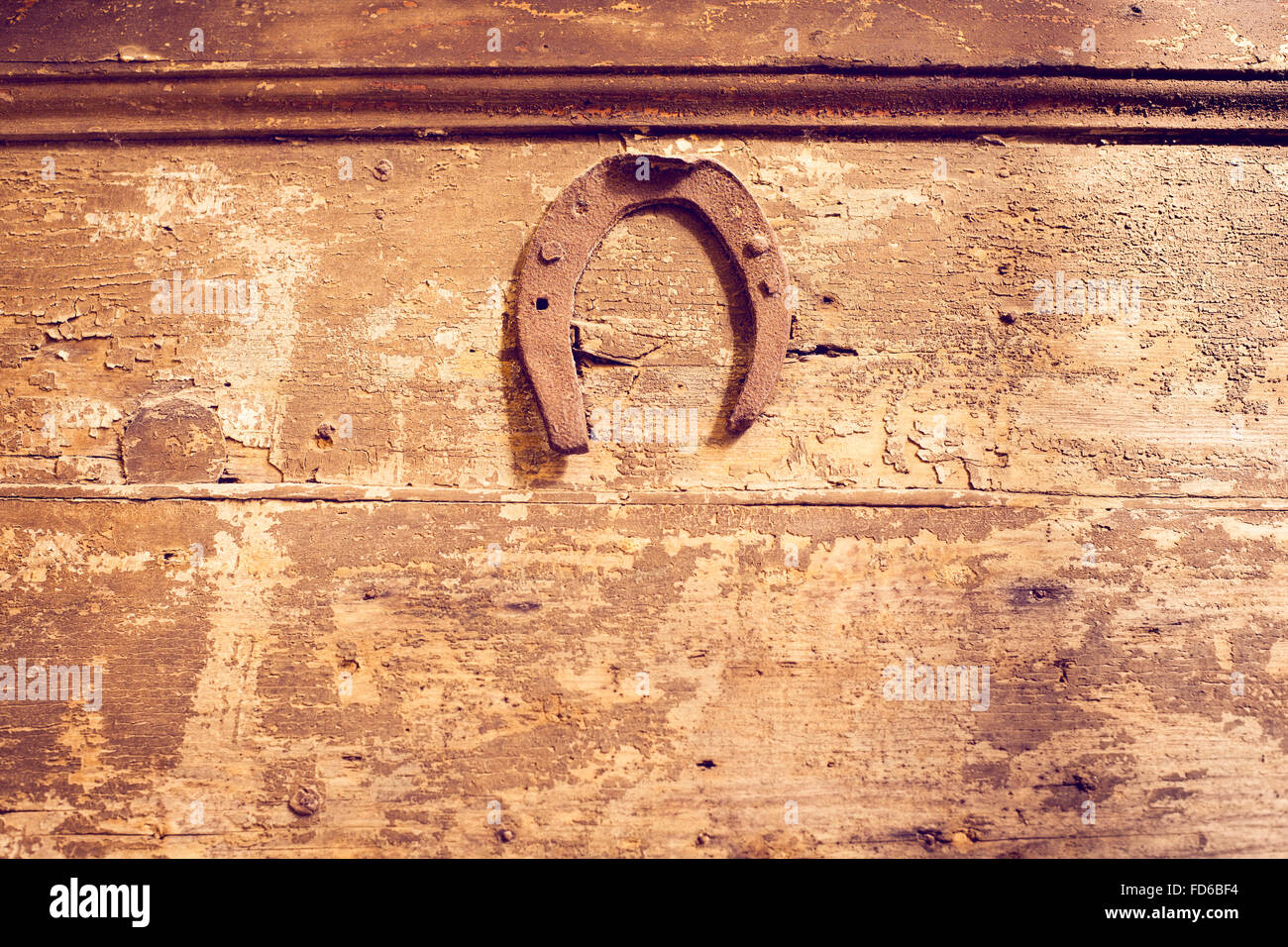 vintage rusty horseshoe nailed at the wooden wall Stock Photo