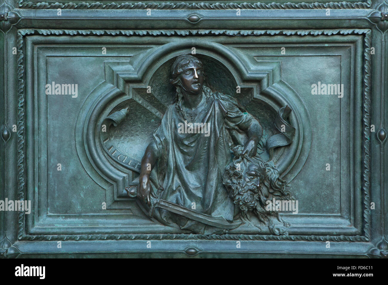 Judith with the Head of Holophernes. Detail of the main bronze door of the Milan Cathedral (Duomo di Milano) in Milan, Italy. The bronze door was designed by Italian sculptor Ludovico Pogliaghi in 1894-1908. Stock Photo