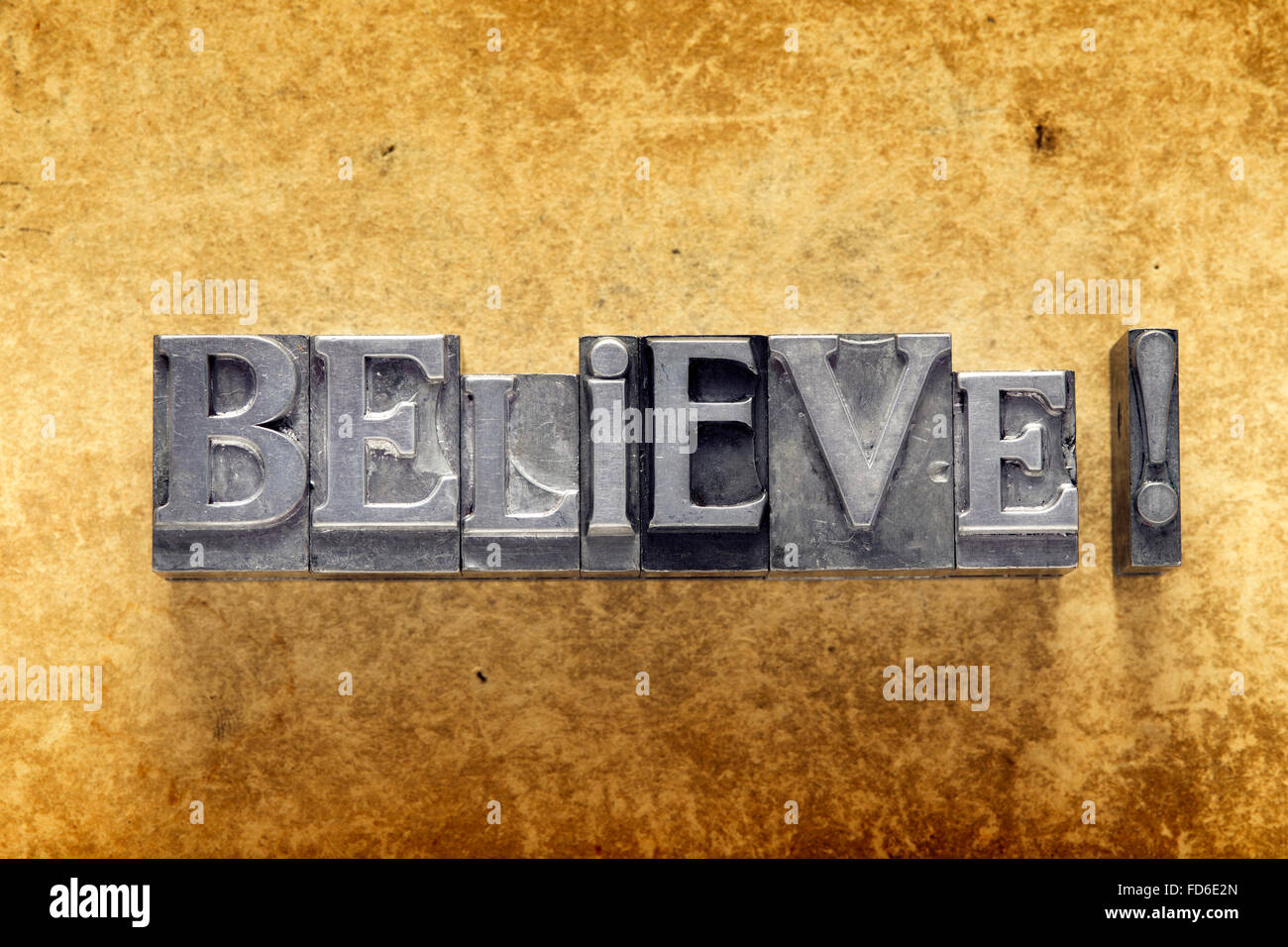 believe exclamation made from metallic letterpress type on vintage cardboard Stock Photo
