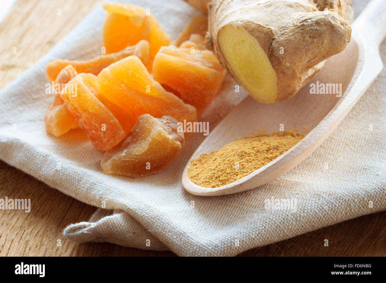 Three kinds of ginger ground spice fresh and candied on rustic table