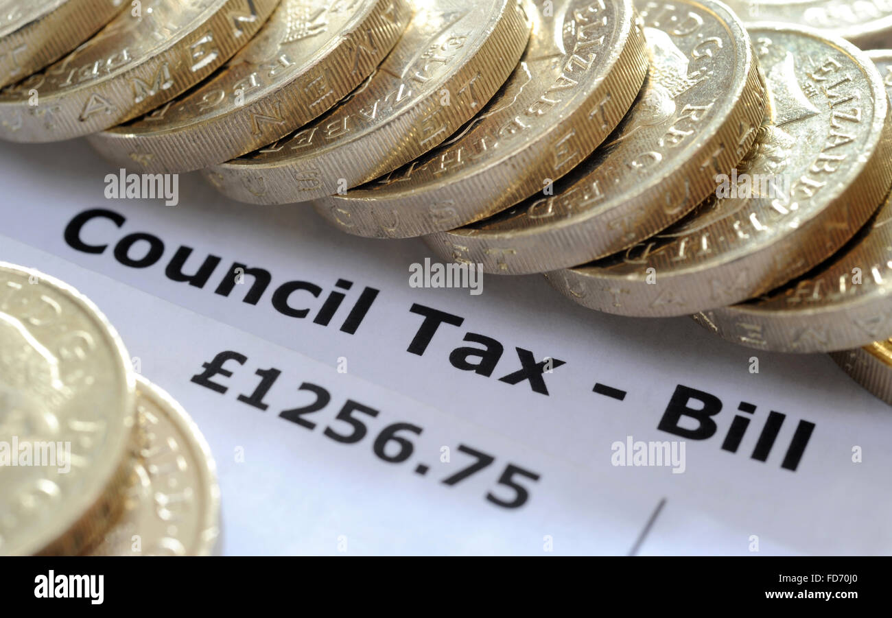 COUNCIL TAX BILL WITH ONE POUND COINS RE HOUSEHOLD INCOMES BILLS BUDGET WAGES GOVERNMENT HOUSE TAX BANDS HOMES WAGES HOUSING UK Stock Photo