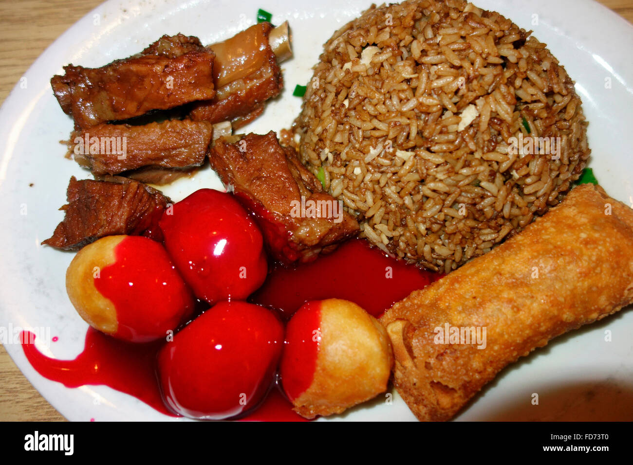 A combination plate of honey garlic ribs, chicken balls and fried rice of North American Canadian Chinese food Stock Photo