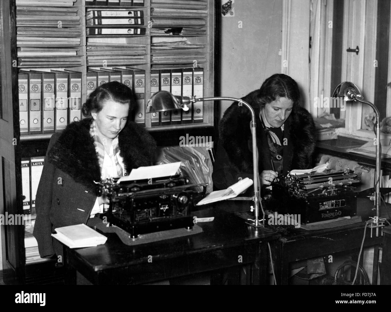 Women with coat in the office, 1940 Stock Photo