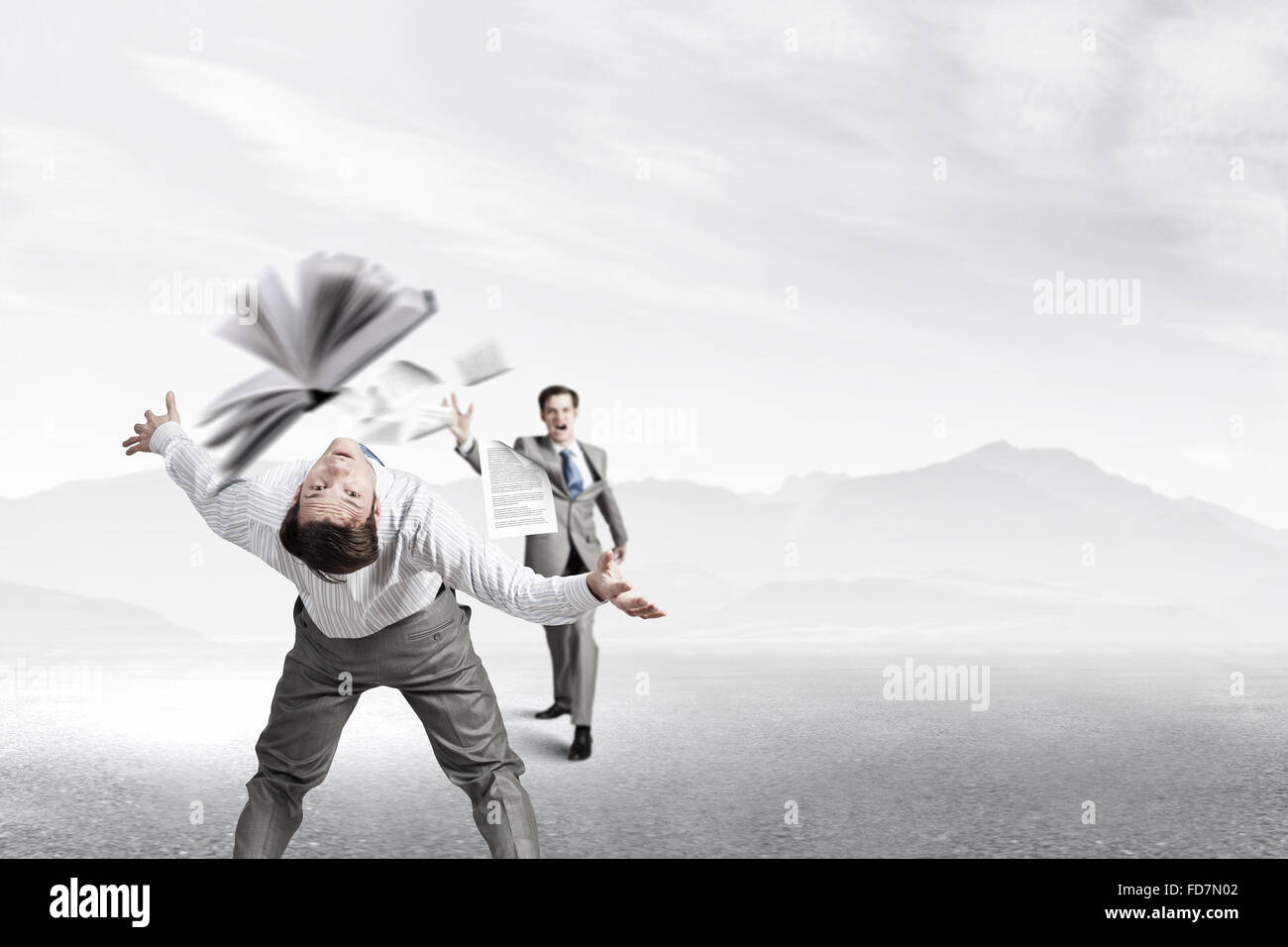 Young businessman trying to evade from thrown book Stock Photo - Alamy