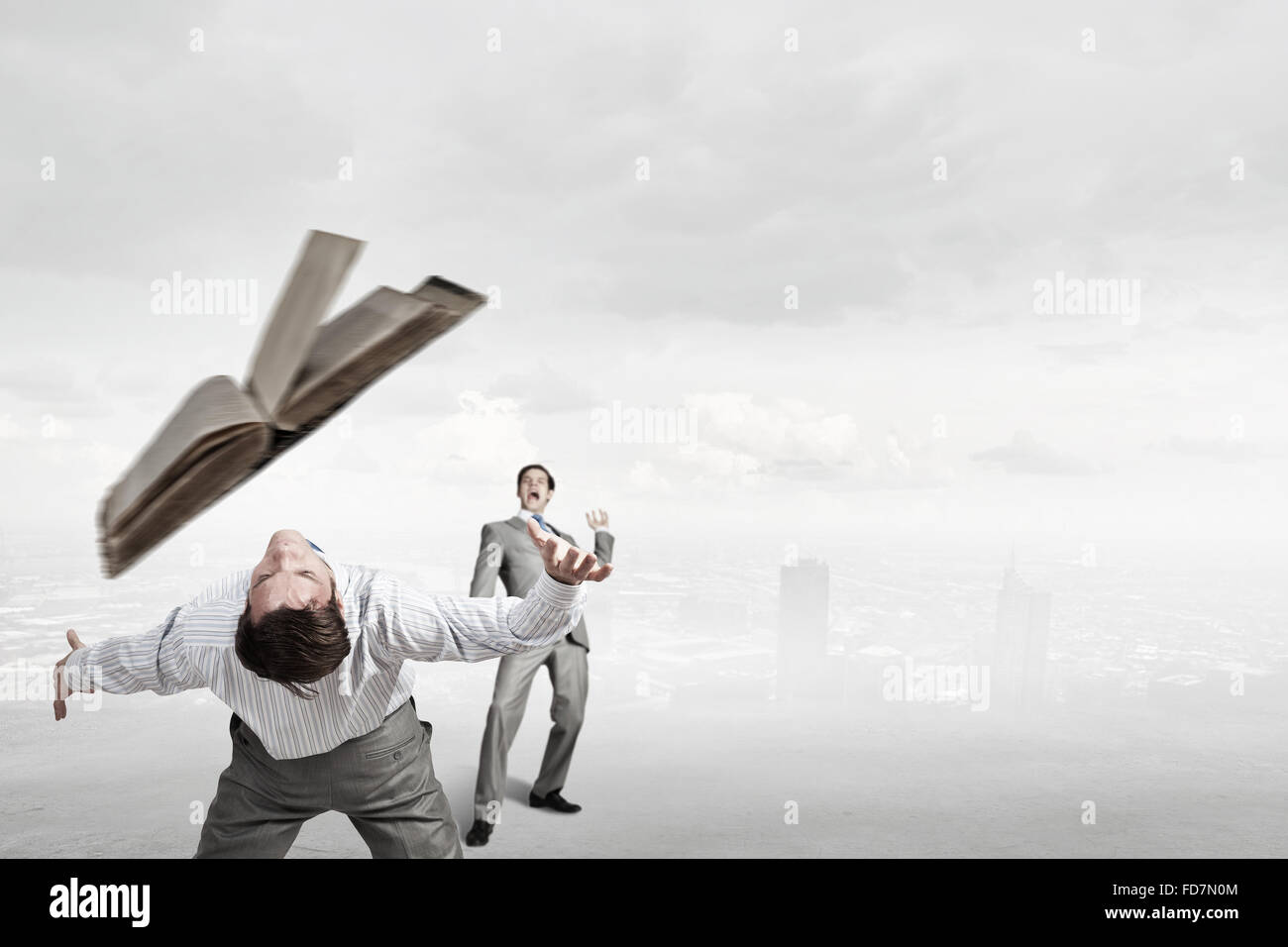 Young businessman trying to evade from thrown book Stock Photo - Alamy