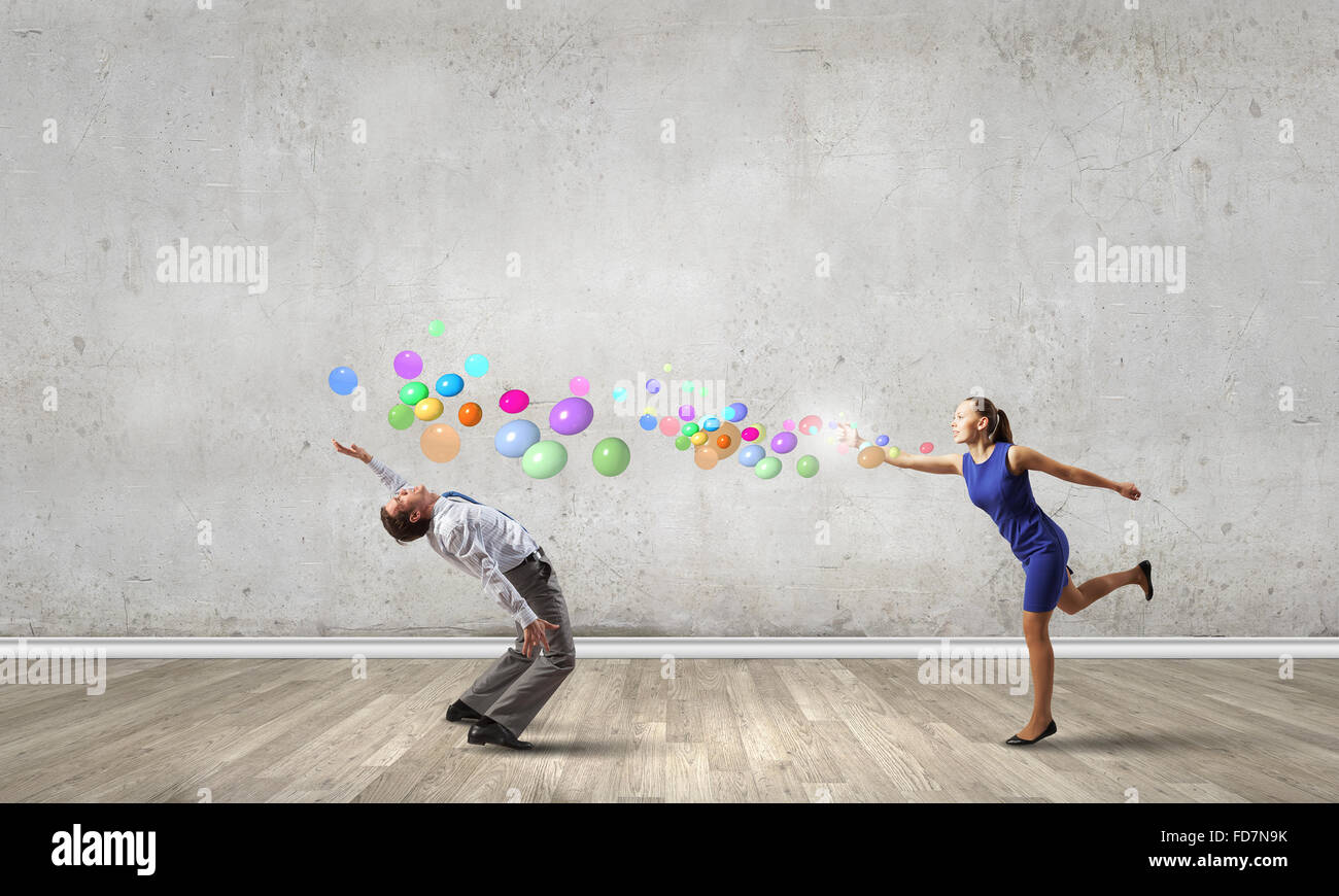 Young businessman trying to evade from thrown colorful balloons Stock ...