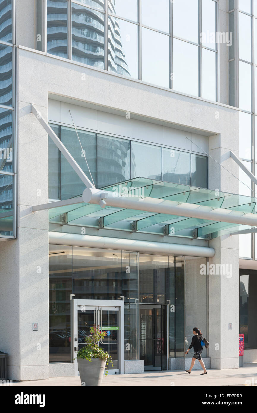 Office workers walking in and out of revolving door at the entrance of an office building. Stock Photo