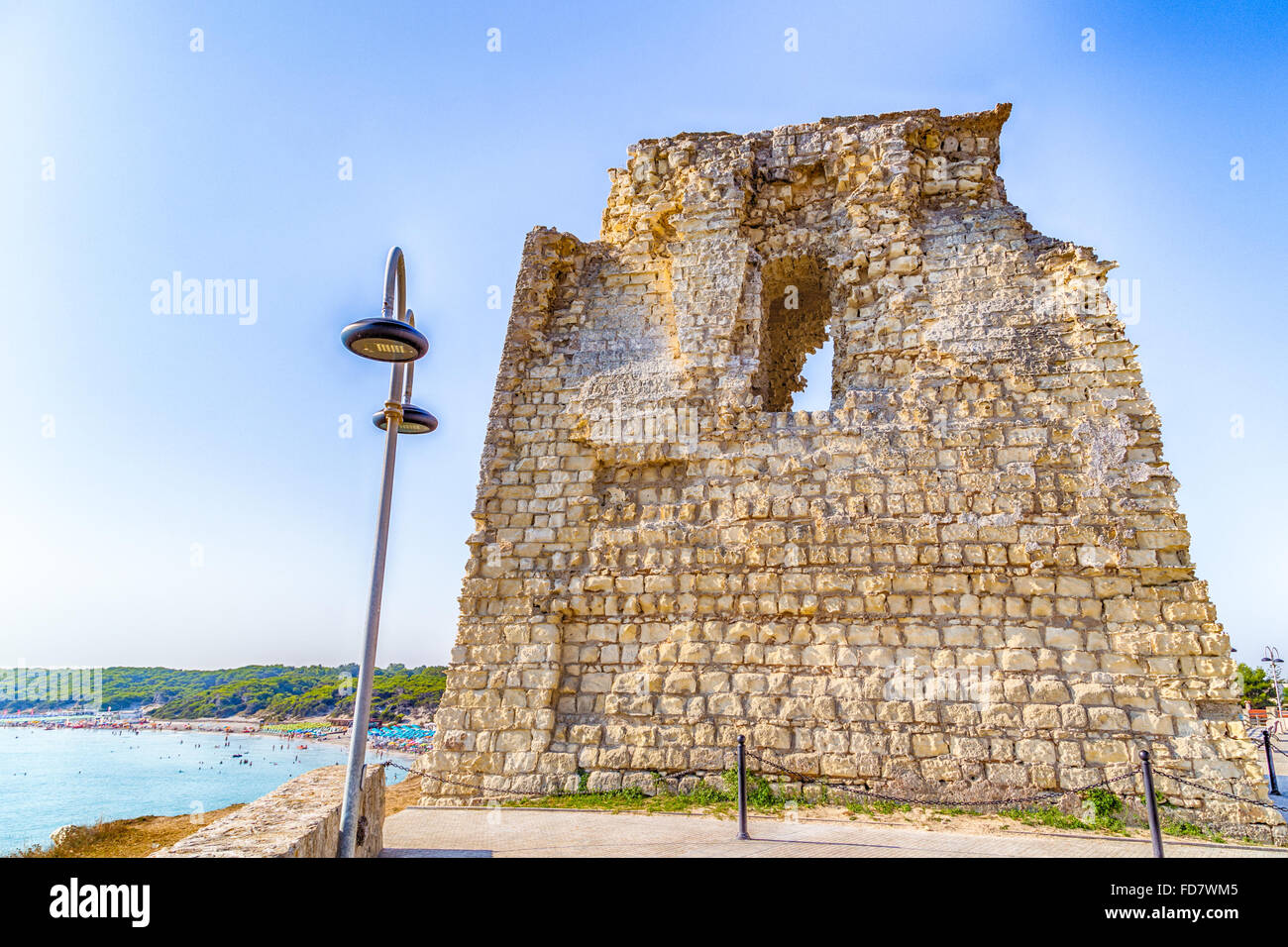 Ruins of ancient watchtower on rocky cove on the coast of Salento in Puglia in Italy Stock Photo