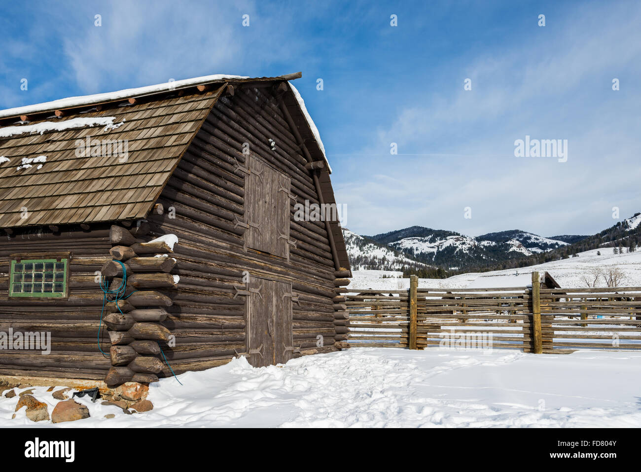 An old log barn in winter snow. Yellowstone National Park, Wyoming, USA. Stock Photo