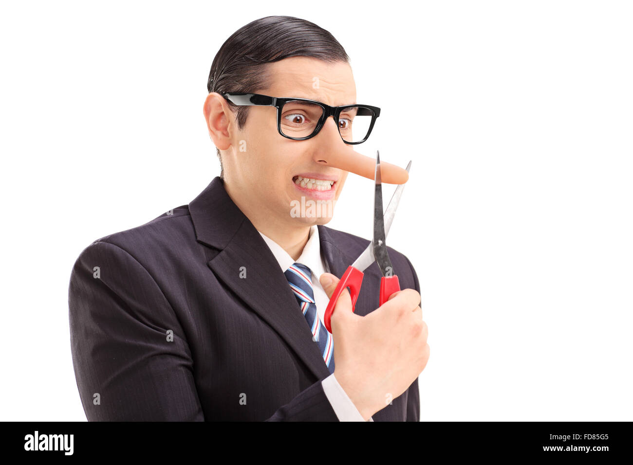 Worried businessman with long nose cutting the tip of his nose with
