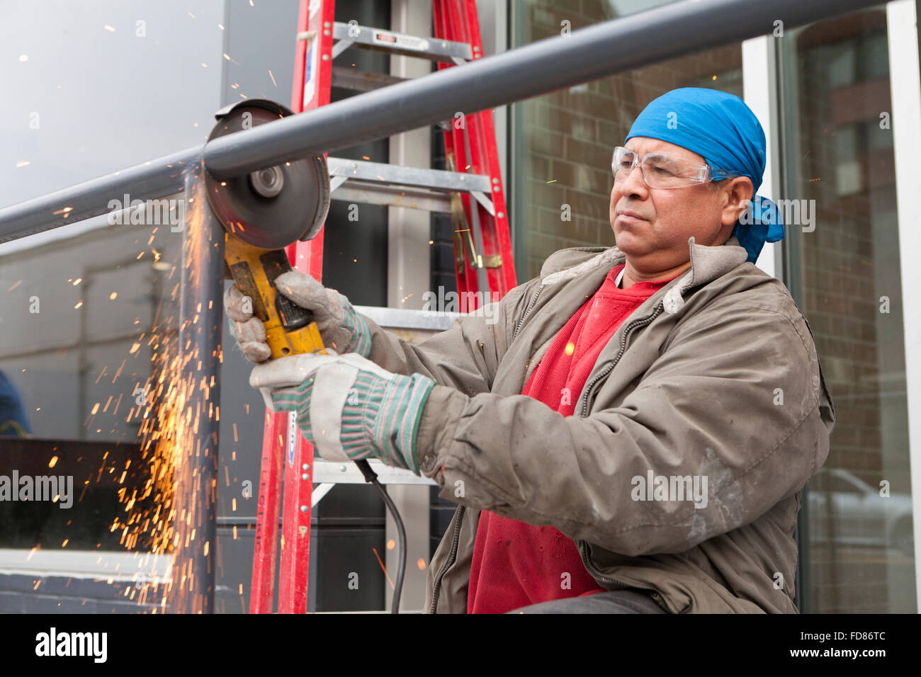 Construction worker cutting steel pipe with angle grinder tool - USA Stock  Photo - Alamy