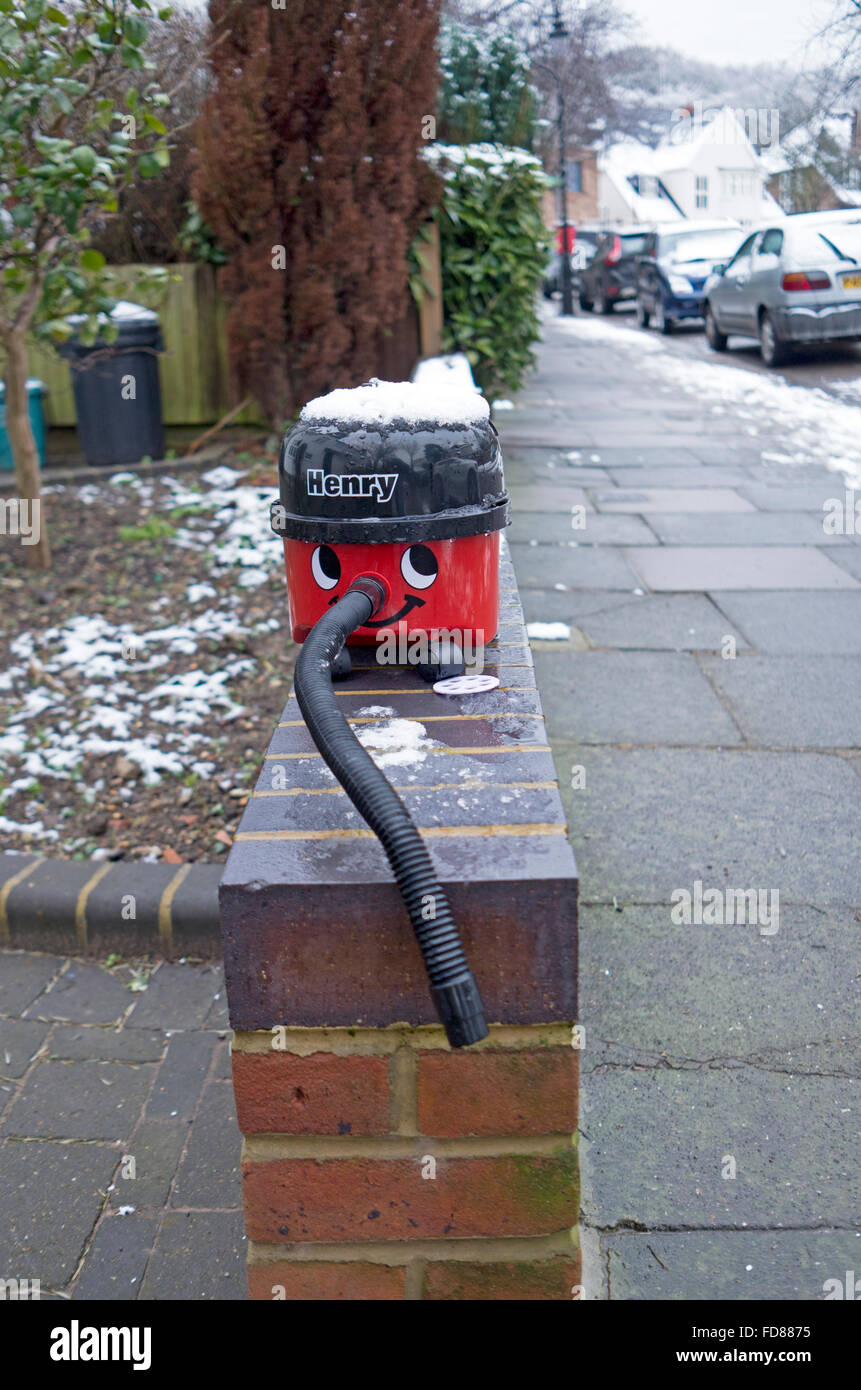 Henry vacuum cleaner capped in snow and dumped on top of a wall Stock Photo
