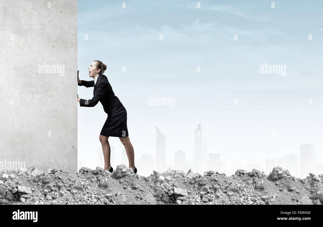 Young businesswoman making effort to move wall Stock Photo Alamy