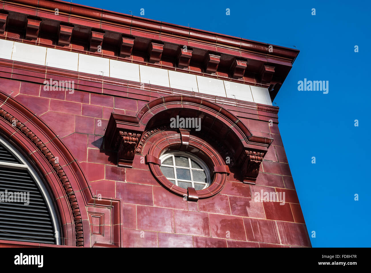 Ornate detail of red tile and window of a Victorian red tiled underground station in Kensington, London. Stock Photo