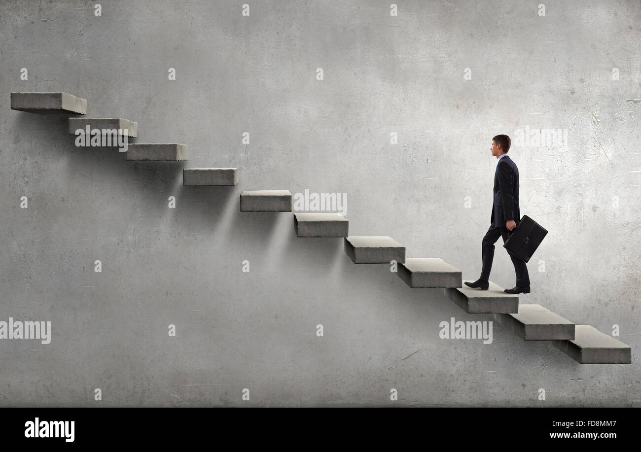 Young businessman walking up on staircase representing success concept ...