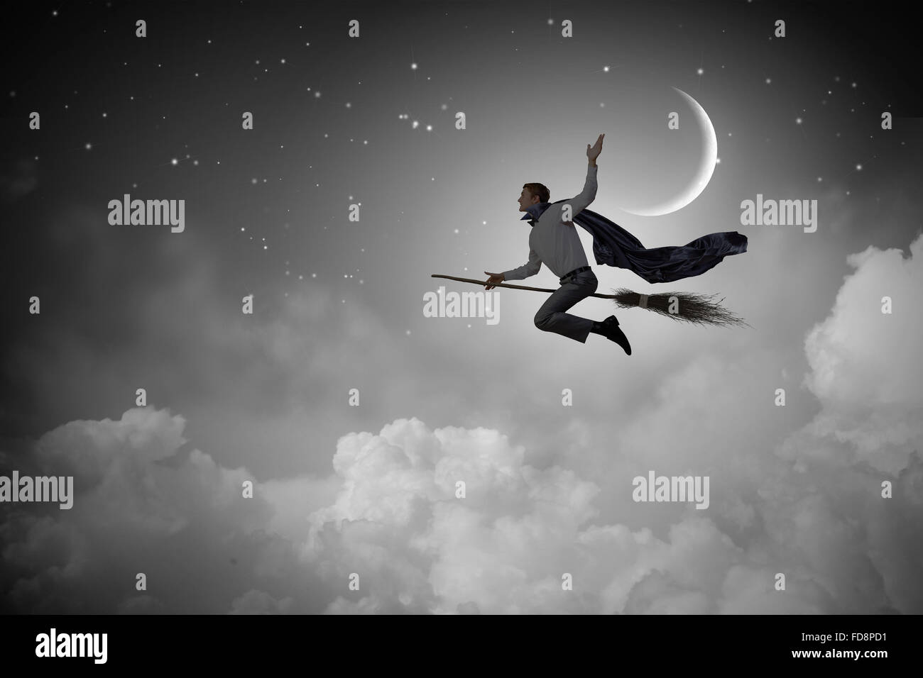 Young businessman flying on broom high in sky Stock Photo Alamy