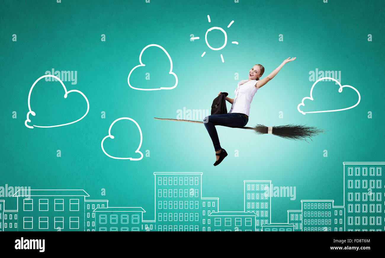 Young girl in casual flying on broom high in sky Stock Photo Alamy