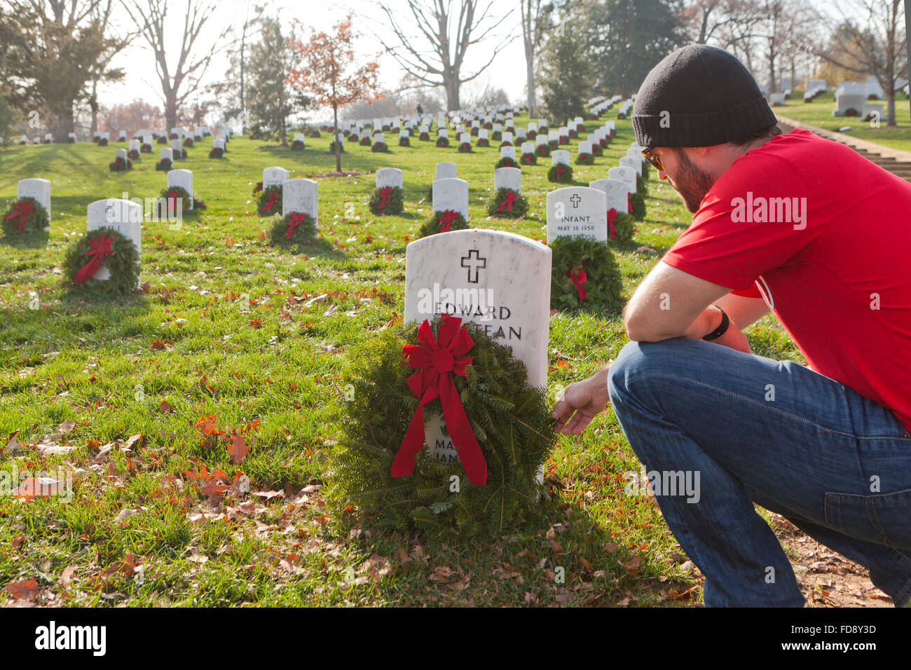 Man laying Christmas wreath at Arlington National Cemetery - Washington, DC USA Stock Photo