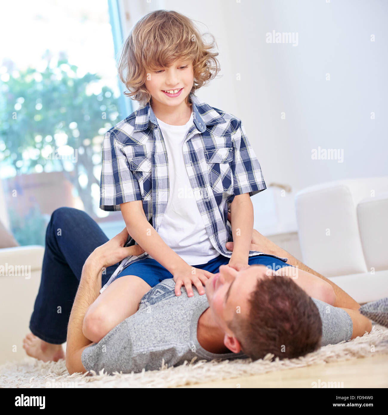 Father and son roughhousing at home in the living room Stock Photo