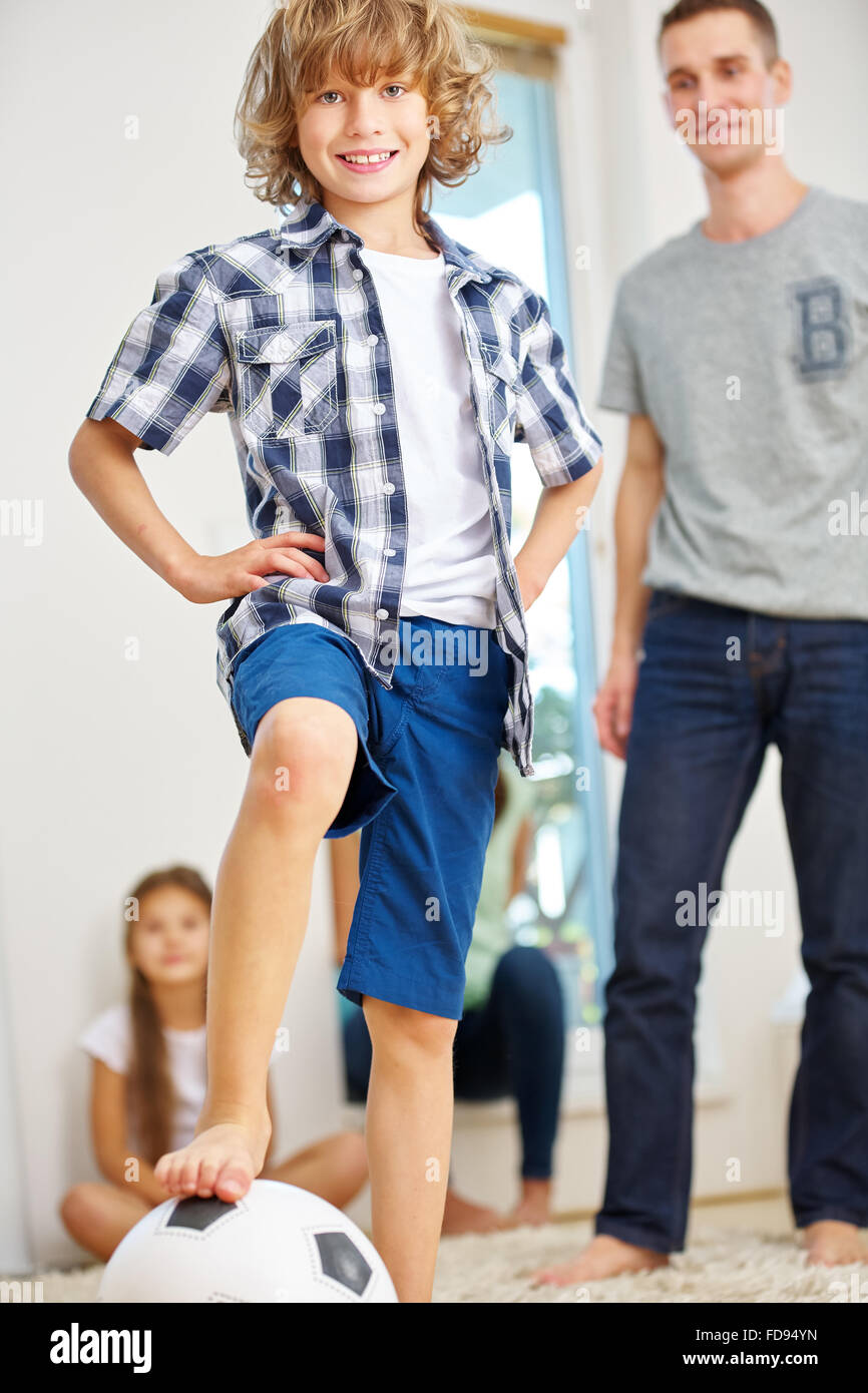 Produ boy with soccer ball and family at home Stock Photo