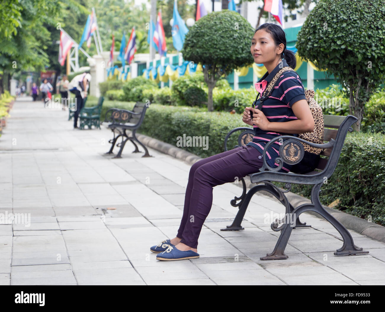 young woman sits on a bench in city Stock Photo - Alamy