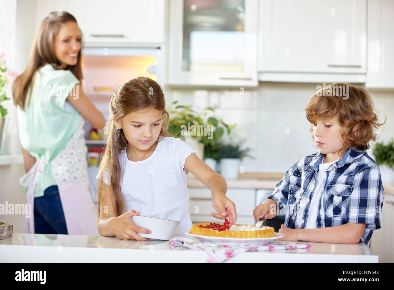 Children baking fruitcake with red currants in the kitchen Stock Photo