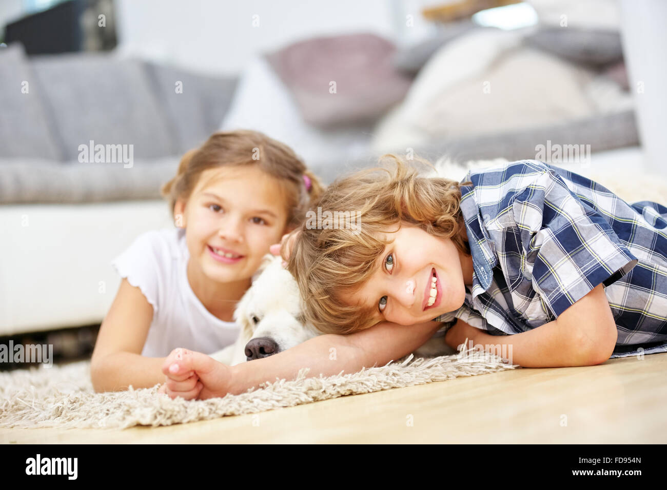 Two happy kids playing with Golden Retriever dog at home Stock Photo ...