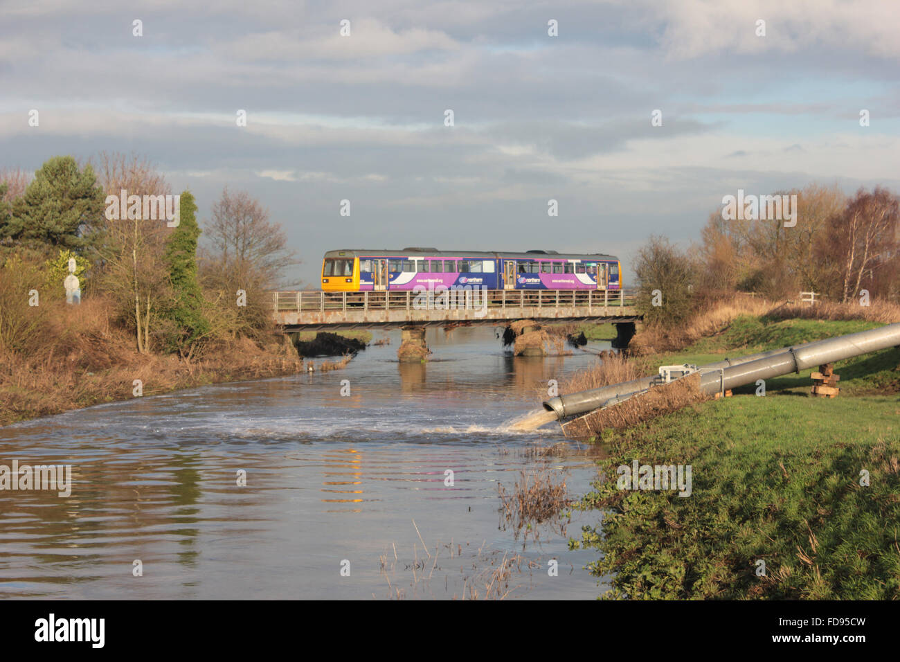 A Northern train service formed of a “Pacer” train crosses the River Douglas in Rufford Stock Photo