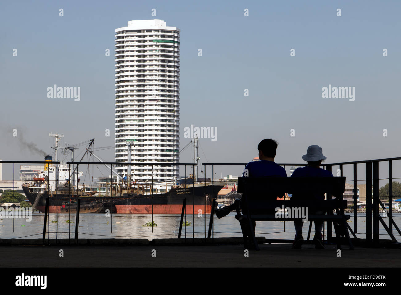 couple sitting on a bench on the waterfront Stock Photo - Alamy