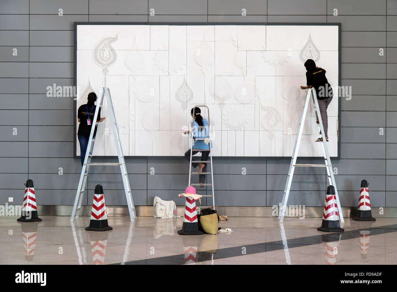 painters paint a picture on the wall in airport Stock Photo