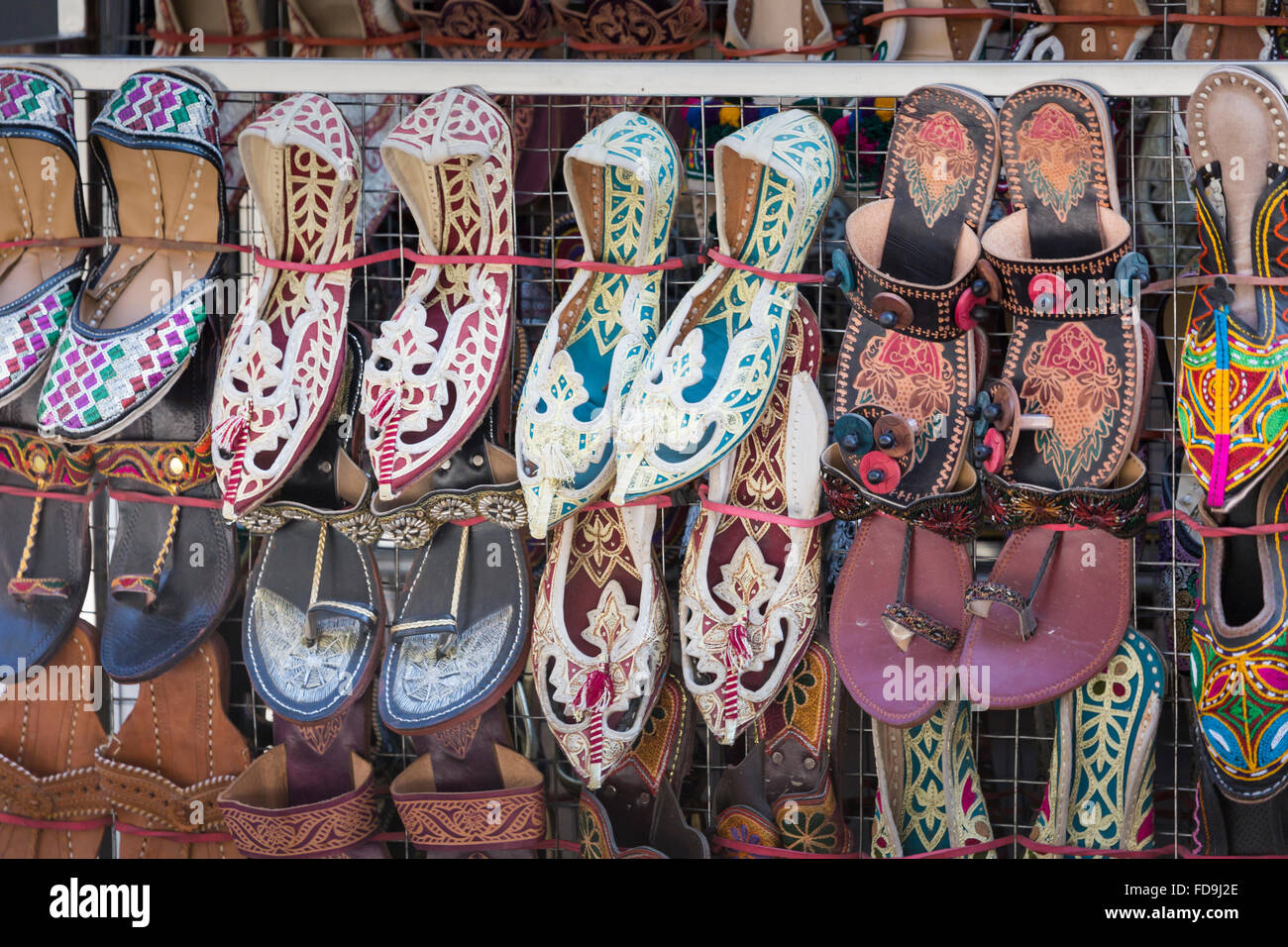 Traditional nepali hempen shoes and vest leaning against a red wall in