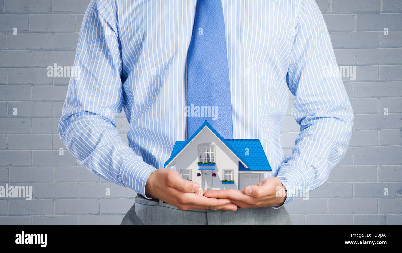 Close up of businessman holding house model in hands Stock Photo - Alamy