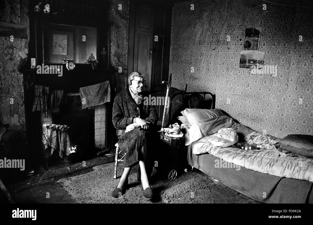 Madge Brazier sits in her basement flat in Buckingham Place Brighton with no heating or lighting because the electricity had been cut off the previous year . Madge cooks using a charcoal burner and uses candles for light .  Photograph taken 25 February 1985 Stock Photo