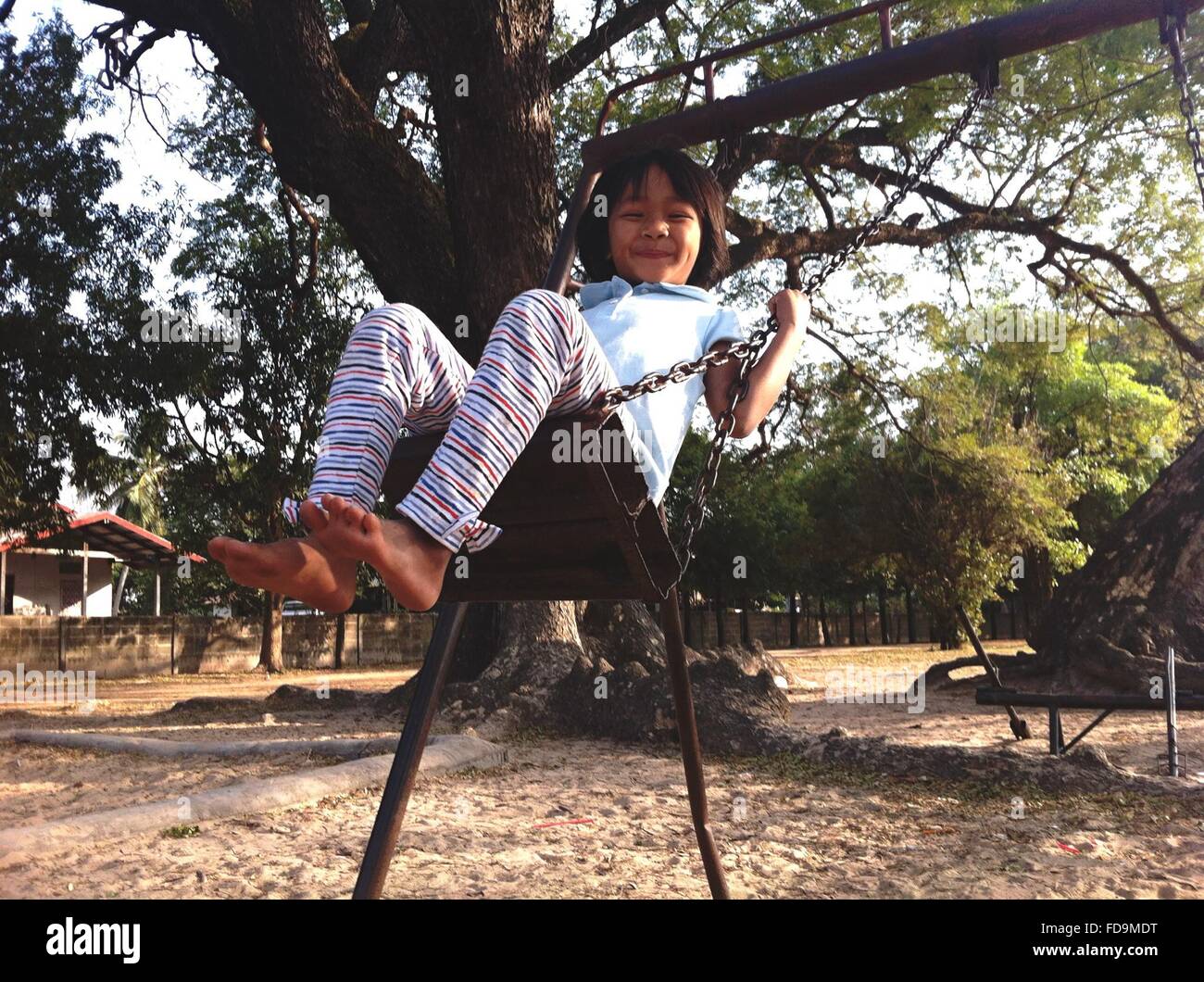 Girl Swinging On Chain Swing Ride And Smiling Stock Photo Alamy