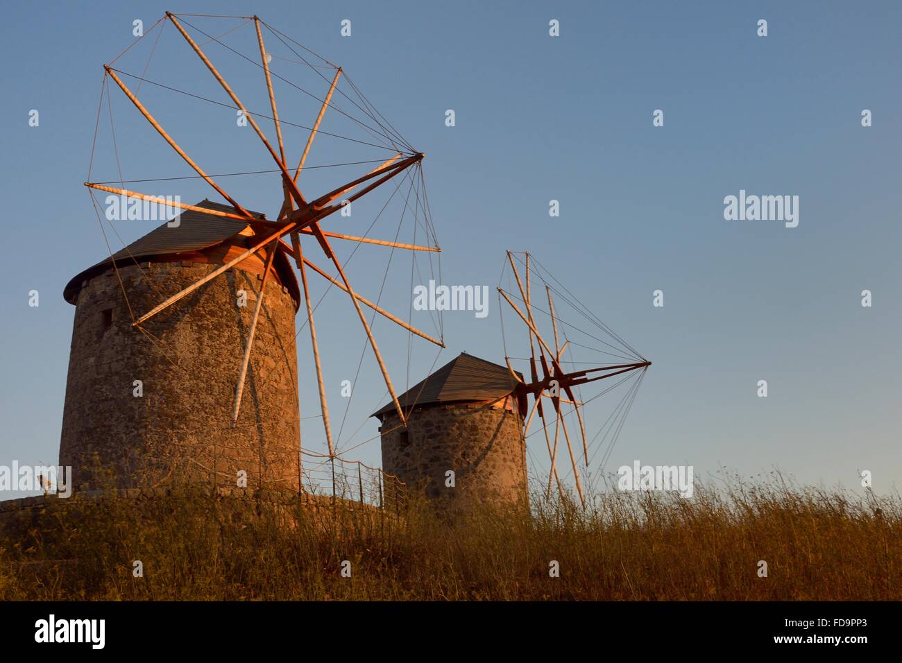 Restored windmills of the Monastery of St. John the Theologian at sunset, Chora, Patmos, Dodecanese Islands, Greece. Stock Photo