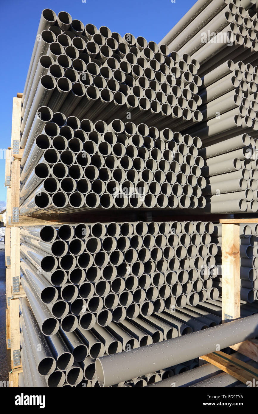 closeup of grey, plastic water pipes stacked in metal frames an