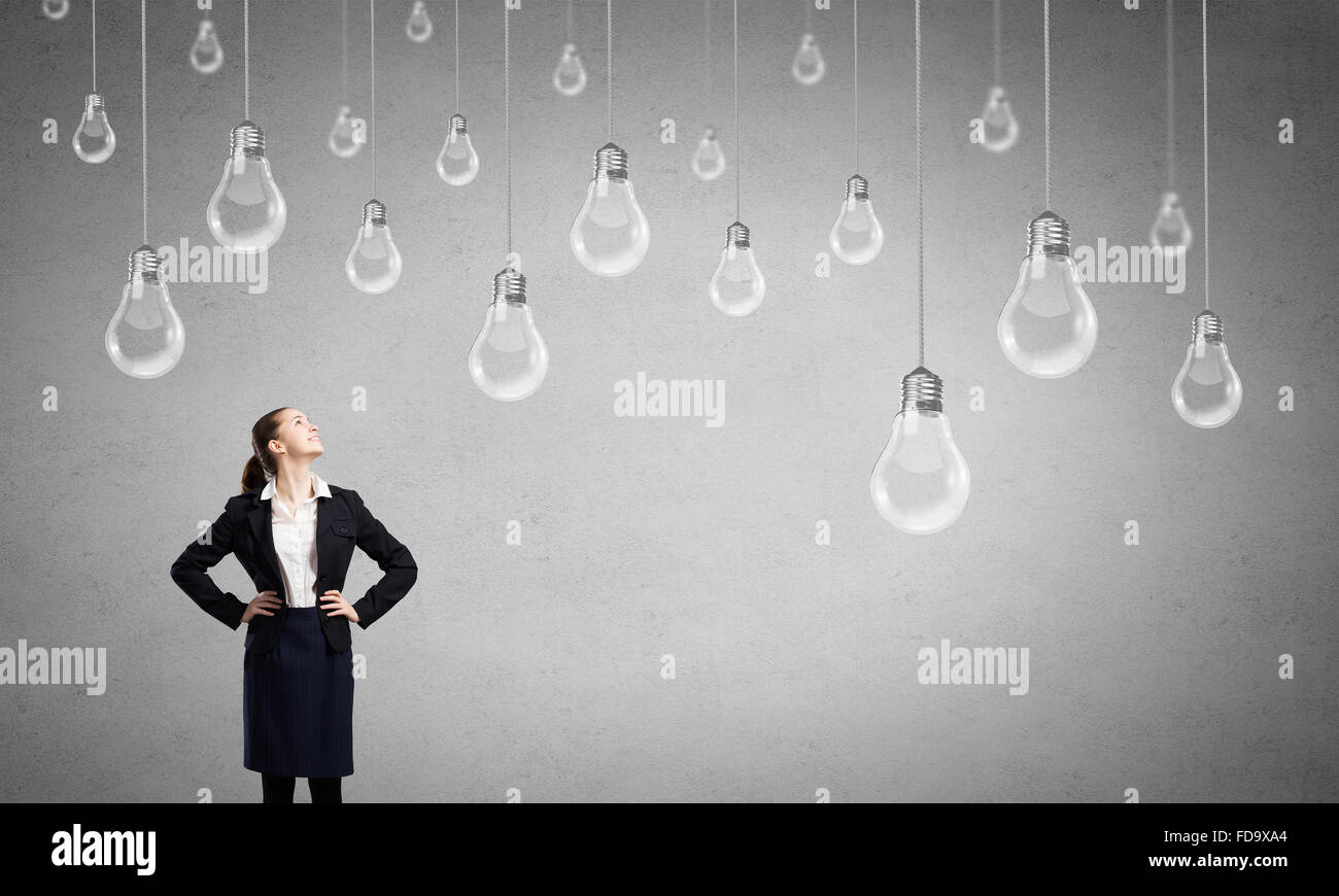 Concept of creativity with woman and light bulbs hanging from above Stock Photo